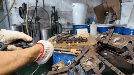 Workers inject PVC paste resin into metal molds using a glue gun