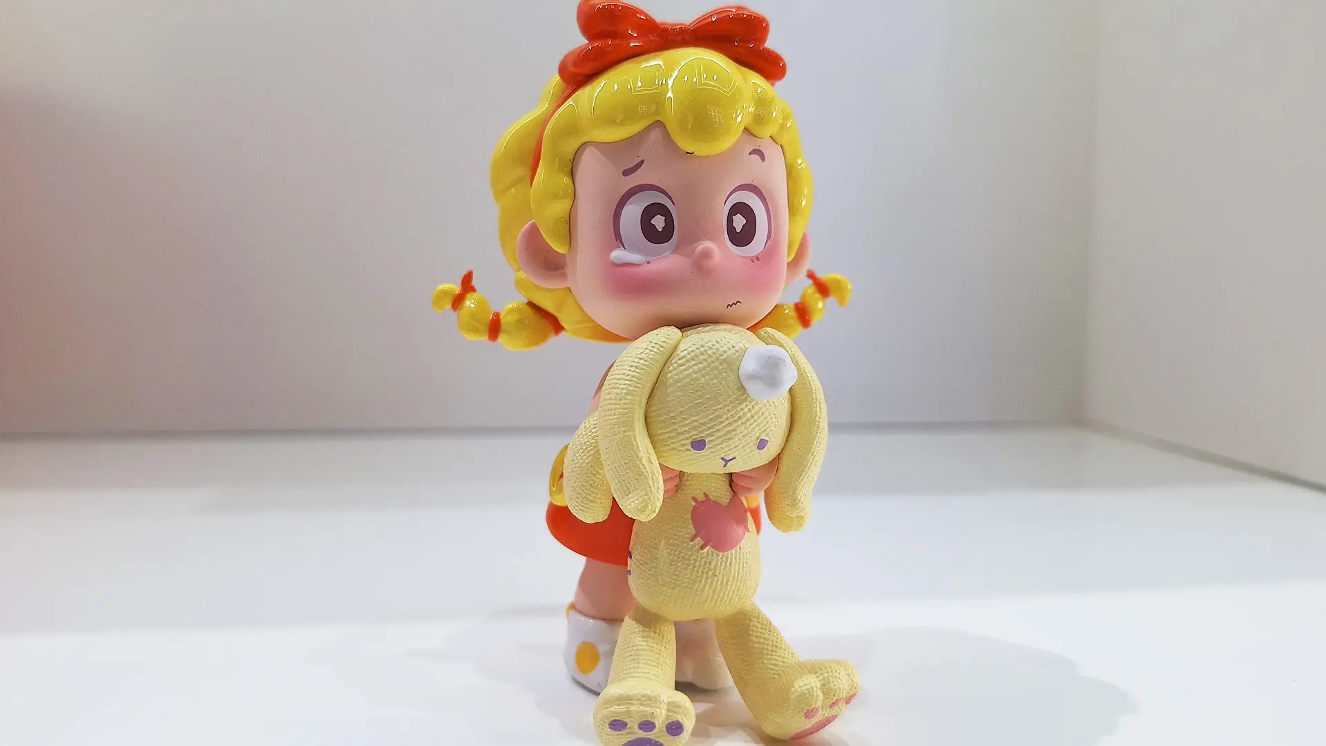 vinyl toy PINY is holding a teddy bear toy