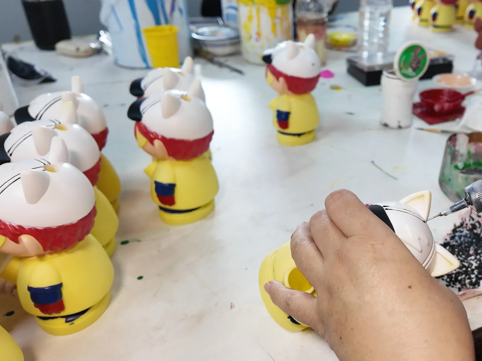 The concave lines on the toy's hat can only be painted by hand, as other methods cannot reach inside these recessed areas.