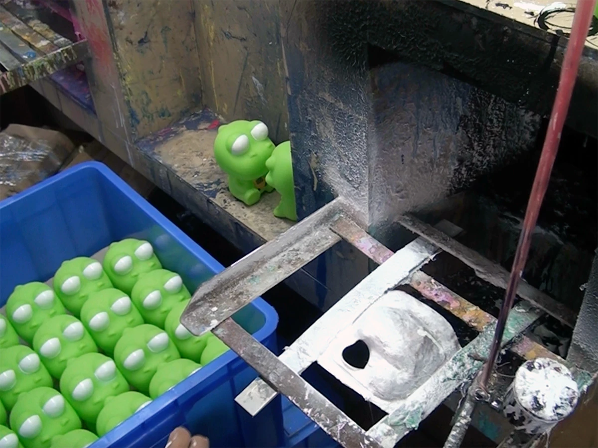 The custom toy is being spray painted using the mask spraying technique.